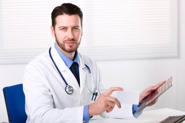 Doctor holding tablet and the box of medicine clipart