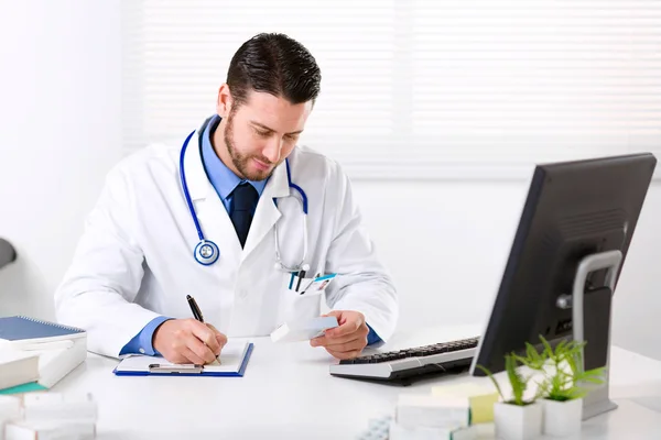 Médico varón escribiendo prescripción — Foto de Stock