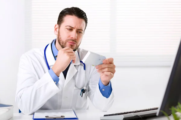 Médico varón leyendo la etiqueta de medicina de la caja de medicina —  Fotos de Stock