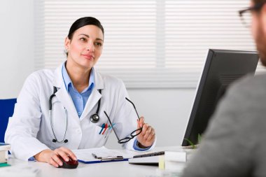 Genç kadın doktor dikkatle dinliyor