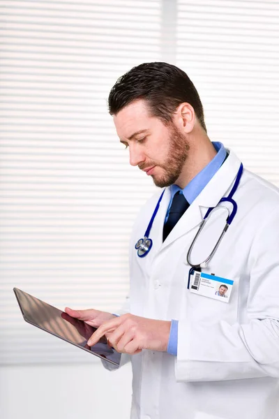 Αρσενικό ο γιατρός στέκεται ενώ εργάζεστε με tablet — Φωτογραφία Αρχείου