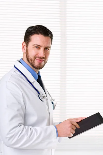 Чоловік лікар стоїть під час роботи з планшетом — стокове фото