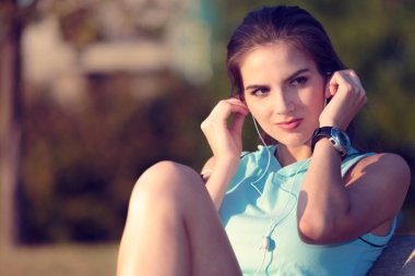 Kadın akıllı telefonundan kulaklık ile müzik dinlemek