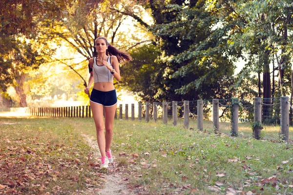 Kadın parkta koşu sırasında müzik — Stok fotoğraf