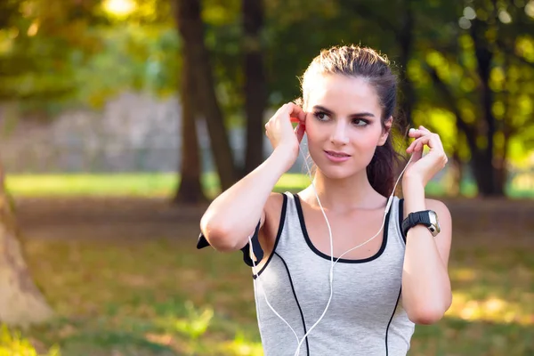 Vrouwelijke atleet, luisteren naar muziek met koptelefoon — Stockfoto