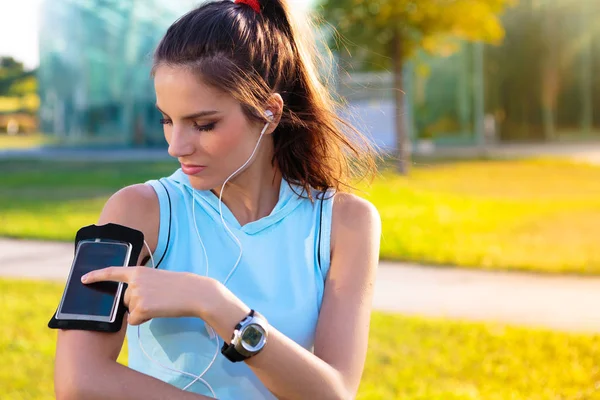 Sportliche Frau hört Musik mit Kopfhörern — Stockfoto