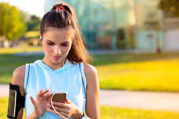 Sportieve vrouw luisteren naar muziek met koptelefoon — Stockfoto