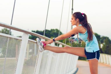 Genç kadın güneşli Park bacak germe