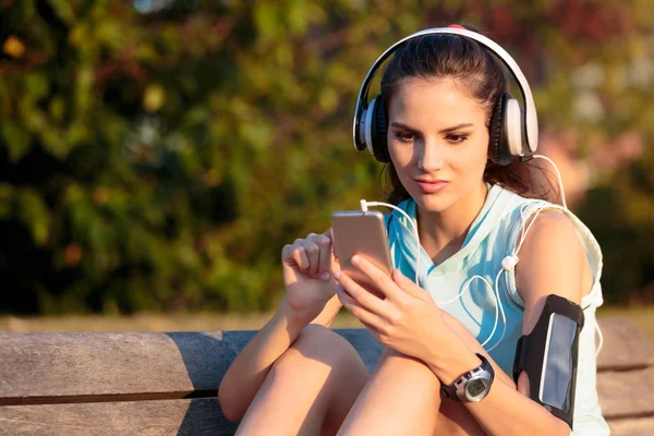 Vrouw luisteren naar muziek met koptelefoon van haar Smartphone — Stockfoto