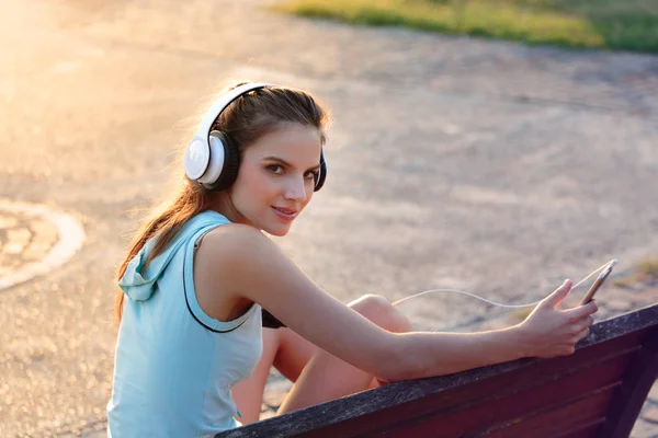 Vrouw luisteren naar muziek met koptelefoon van haar Smartphone — Stockfoto