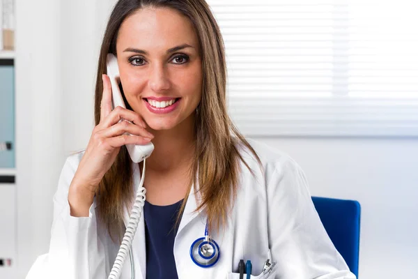 Lächelnde Ärztin mit Telefon am Ohr — Stockfoto