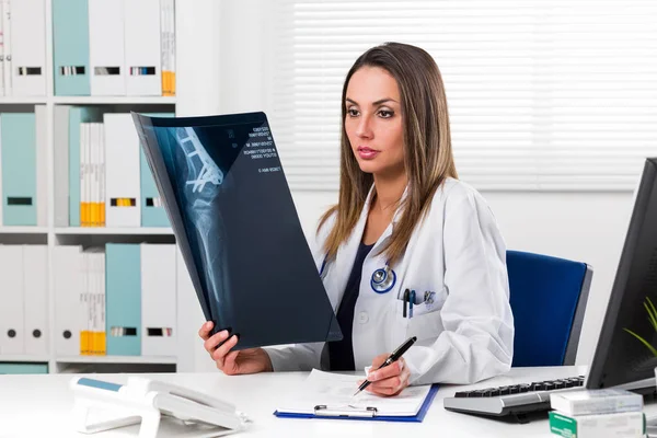 Γυναίκα γιατρό βλέπουν ασθενείς ακτινογραφία στο γραφείο της — Φωτογραφία Αρχείου