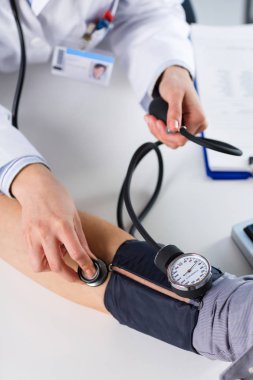 Kadın Doktor hastanın kan basıncını kontrol