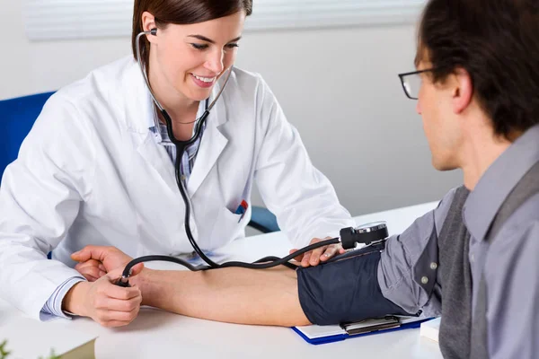 女性の医者が患者の血圧をチェックします。 — ストック写真