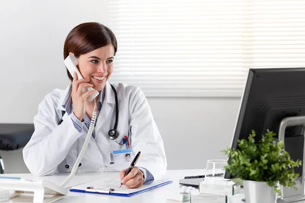 책상 전화에 여성 의사 — 스톡 사진