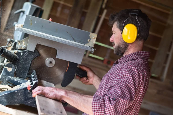 Daire testere tarafından erkek marangoz kesme tahtası — Stok fotoğraf