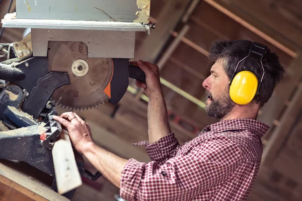 Mužské prkno Carpenter řezání kotoučovou pilou — Stock fotografie