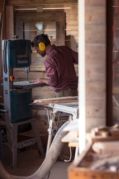 Мужской плотник режущий доску ленточная пила — стоковое фото