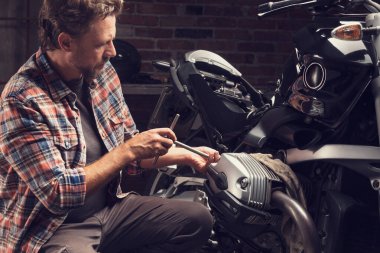 Tamirci eski bir bisiklette priz anahtarı kullanıyor.