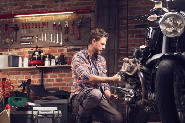 Mechanic using a wheel spanner on a vintage bike