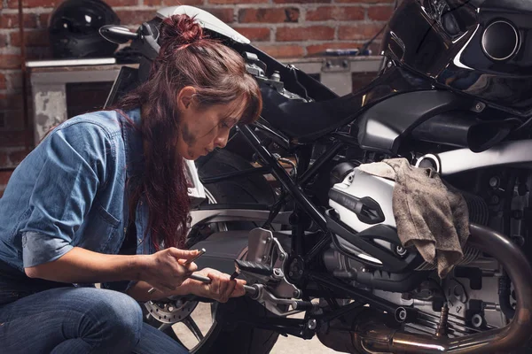 ヴィンテージバイクで働く女性整備士 — ストック写真