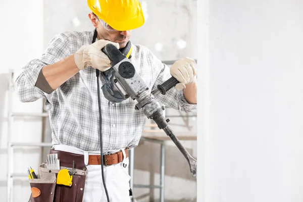 Perforación del constructor utilizando un taladro de mano eléctrico —  Fotos de Stock