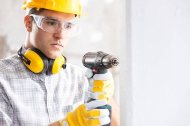 Builder drilling a hole in a new wall