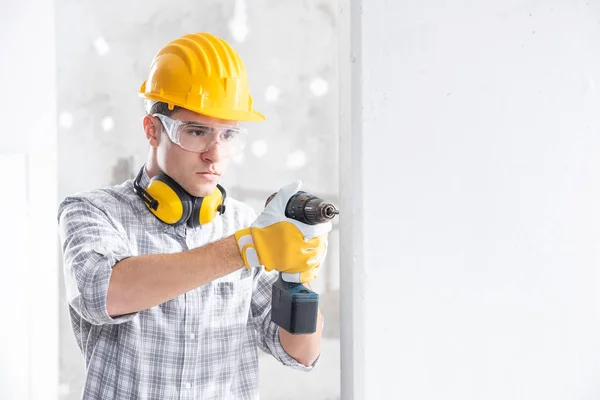 Constructor perforando un agujero en una nueva pared —  Fotos de Stock