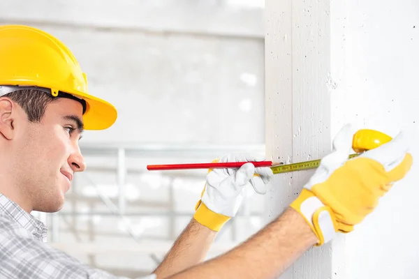 Trabajador de la construcción midiendo la pared — Foto de Stock