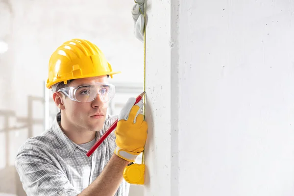 Bouwvakker meten van de muur — Stockfoto