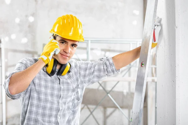 Builder talking on his mobile phone on site