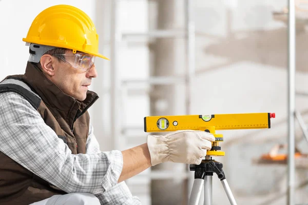 Construtor ou trabalhador ajustando um nível de espírito — Fotografia de Stock