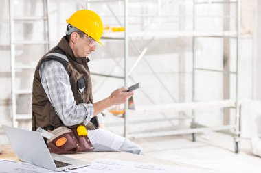 Builder or contractor using a mobile phone on site
