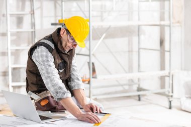 Architect or builder measuring a blueprint drawing
