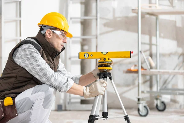 Construtor ou trabalhador ajustando um nível de espírito — Fotografia de Stock