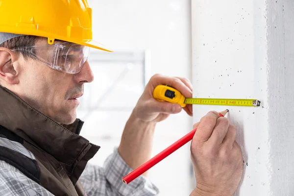 Costruttore marcatura di una misura con una matita — Foto Stock