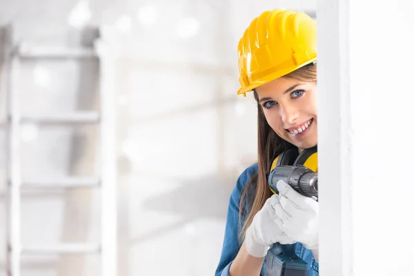 Junge Bauarbeiterin Bohrt Vor Ort Mit Einer Batteriebetriebenen Handbohrmaschine Ein — Stockfoto