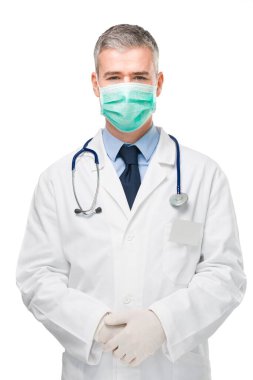 Doktor, Covid-19 veya Corona virüsüne karşı önlem olarak cerrahi ya da solunum maskesi, laboratuvar önlüğü ve eldiven takıyor.