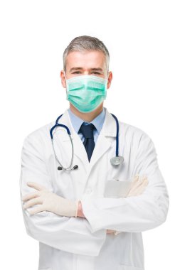 Doktor, Covid-19 veya Corona virüsüne karşı önlem olarak cerrahi ya da solunum maskesi, laboratuvar önlüğü ve eldiven takıyor.