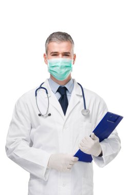 Doktor laboratuvar önlüğü, cerrahi maske, eldiven ve steteskop ile elinde bir hasta dosyası ya da tıbbi notlar tutuyordu.