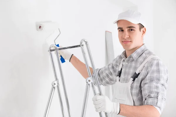 Amable Joven Pintor Masculino Pintando Una Pared Blanca Con Rodillo — Foto de Stock