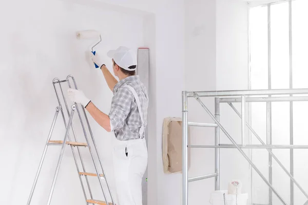 Pintor Pie Una Escalera Pintando Una Pared Blanca Una Habitación — Foto de Stock