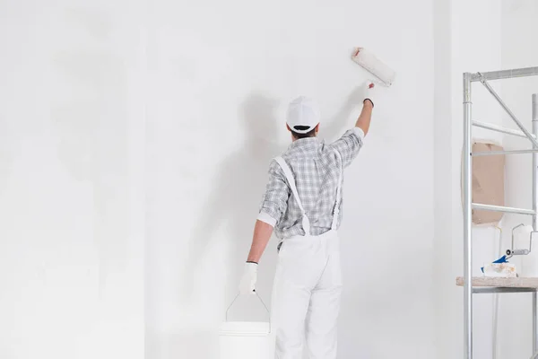 Malarz Lub Budowniczy Malujący Ścianę Białą Farbą Rolkę Oglądaną Tyłu — Zdjęcie stockowe