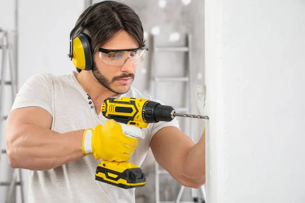 Muscular Constructor Con Sombrero Fuerza Gafas Perforación Agujero Una Pared — Foto de Stock