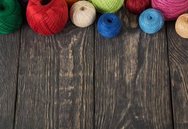 Kadınların hobisi. Ahşap arka planda renkli iplik izleri.