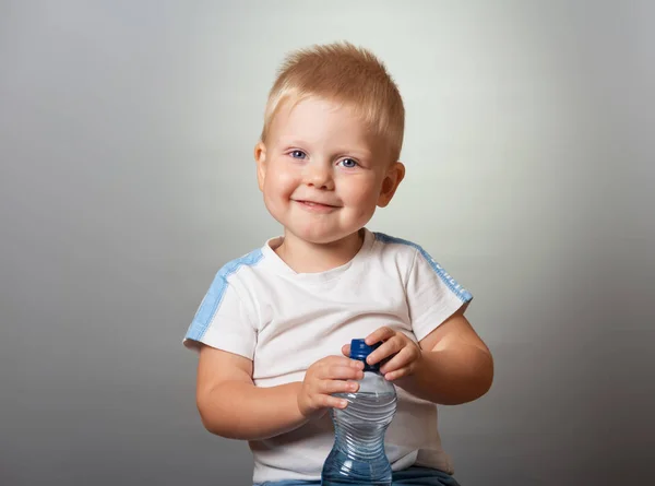 Zadowolony chłopak z guty z butelką wody — Zdjęcie stockowe