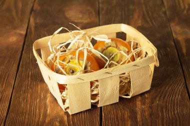 Tahtadaki ahşap sepette taze sulu hurmalar.