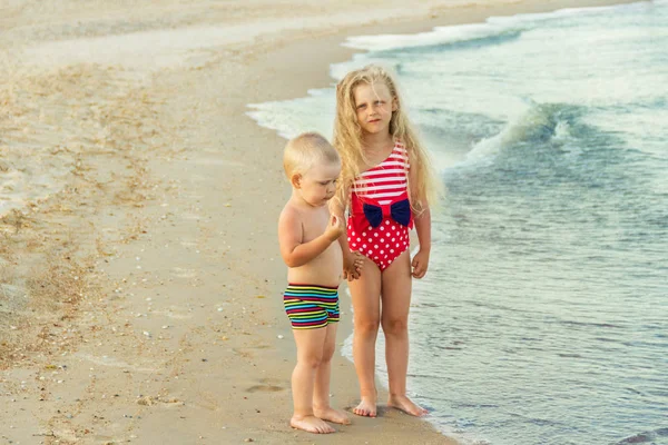 Broder og søster på sandstrand tur på vandet - Stock-foto