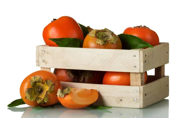 Verse rijpe persimmon in een houten doos en gesneden stukken geïsoleerd op wit — Stockfoto