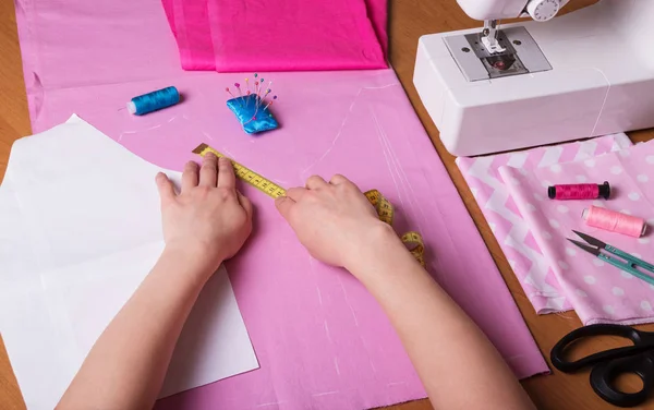 Mãos femininas de uma costureira que faz um modelo no local de trabalho de costureira — Fotografia de Stock